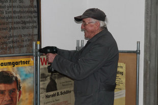 Hans Pscheidl schraubt mit dem Akku zwei historische Wahlplakate zusammen. (Foto: Rau)
